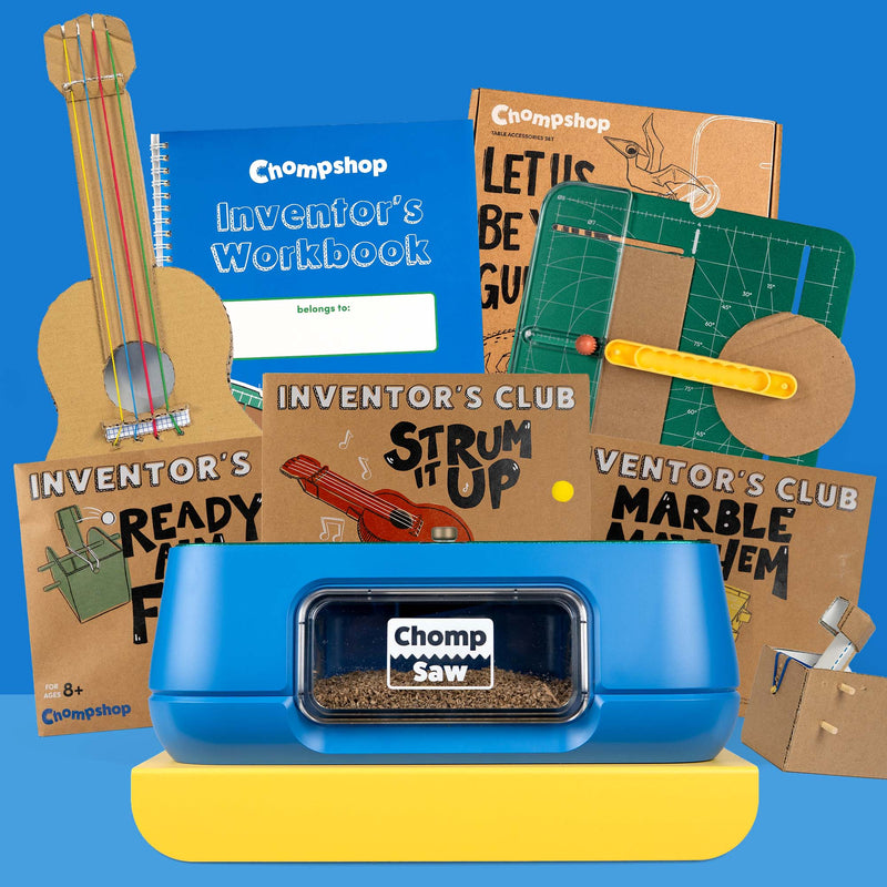 A Chompshop inventor-themed toy set arranged on a bright blue background, featuring a blue ChompSaw in the foreground, cardboard projects and other craft/learning items.