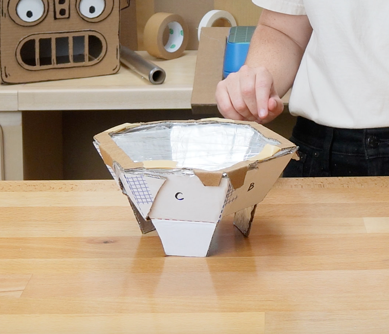 photo of cardboard solar oven on table