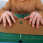 Person using the ChompSaw to cut through a piece of cardboard from an internal cut