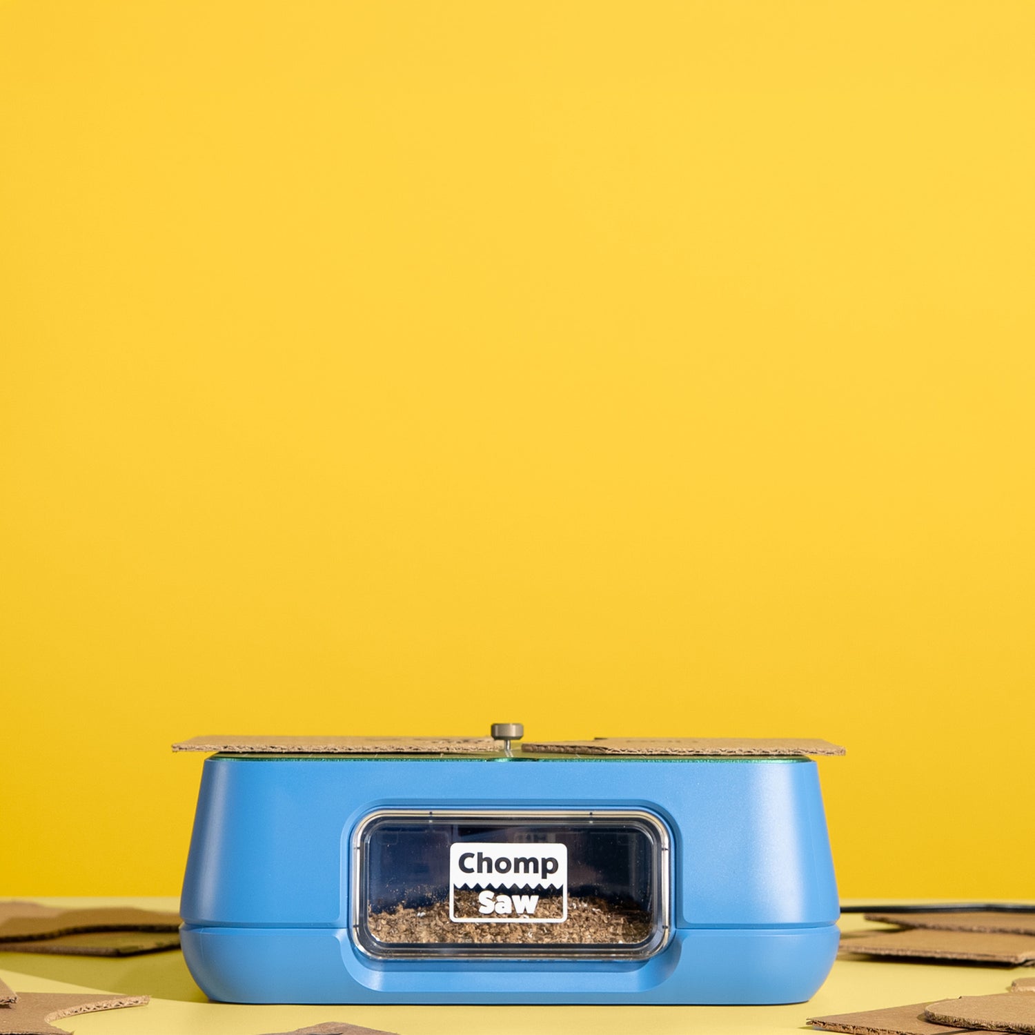 The ChompSaw kids power tool with its dust-collection drawer full of cardboard shavings and freshly cut pieces.