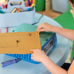 Young maker using the ChompSaw to cut from the middle of a cardboard sheet.