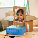 Young maker holding a decorative cardboard picture frame she built with the ChompSaw kids power tool.