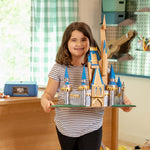 Young maker holding a decorative cardboard castle built with the ChompSaw.