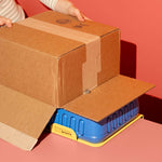 Cutting a large cardboard box with the ChompSaw, stabilized by the Chompin' Station for Big Chomps table hook accessory.