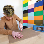Child scoring a piece of cardboard for a fold using the scoring tool
