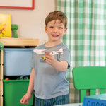 Kid showing off a cardboard airplane he built with the ChompSaw kids power tool.