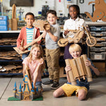 Kids holding a variety of cardboard projects made with the ChompSaw.