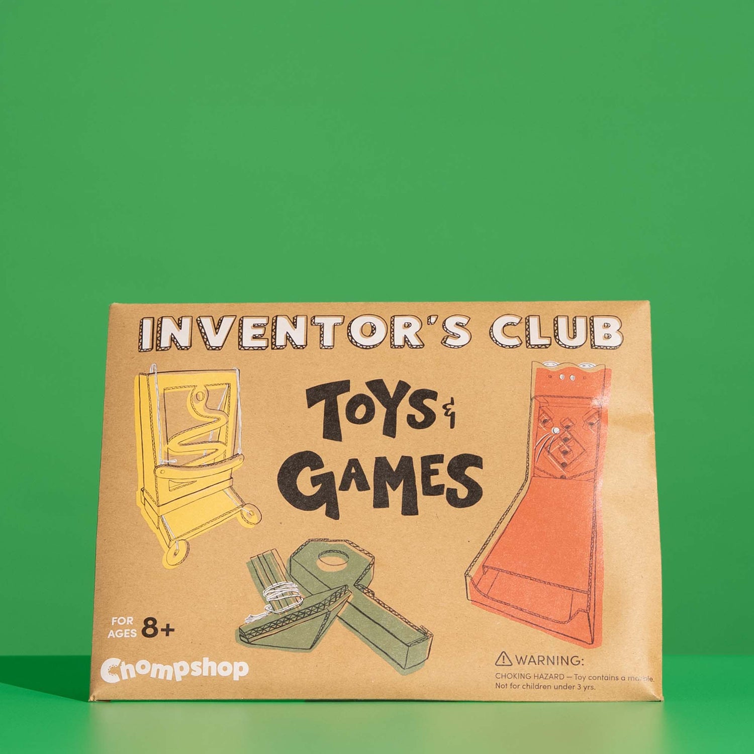 Cardboard packaging for Chompshop's 'Toys & Games' cardboard project pack on a green background